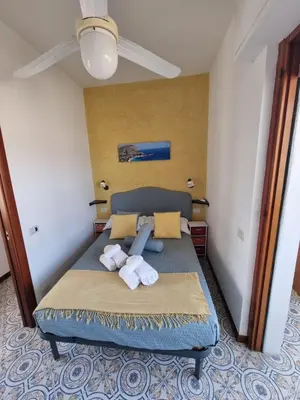a bedroom with a blue bed with towels on it at Villa Emilia Mondello Appartamento Emily con vista sul mare in Palermo