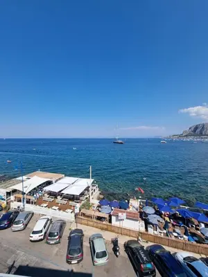 a parking lot with cars parked next to the water at Villa Emilia Mondello Appartamento Emily con vista sul mare in Palermo