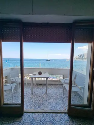 a view of the ocean from a room with a table and chairs at Villa Emilia Mondello Appartamento Emily con vista sul mare in Palermo