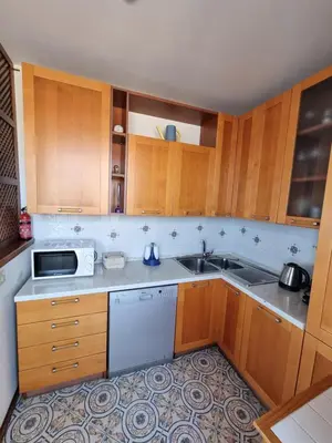 a kitchen with wooden cabinets and a sink at Villa Emilia Mondello Appartamento Emily con vista sul mare in Palermo