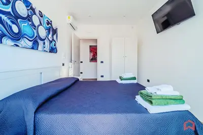 a bedroom with a blue bed and a tv at Villa con Piscina sul Mare a Terrasini in Terrasini