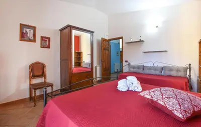 a bedroom with a red bed with towels on it at 4 Bedroom Stunning Home In Trappeto in Trappeto