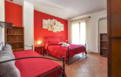 a red bedroom with two beds and a red wall at 4 Bedroom Stunning Home In Trappeto in Trappeto