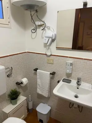 a bathroom with a sink and a toilet and a mirror at Petit Maison in Palermo