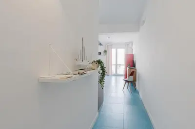 a living room with a bed and two white chairs at Orizzonte Blu apartment - Macari Bay in Macari