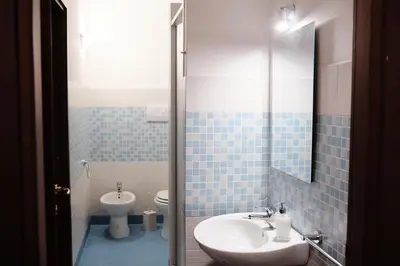 a blue tiled bathroom with a sink and a toilet at Al bastione della pace in Palermo