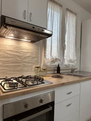 a kitchen with a stove top oven next to a window at Casa Andrew in Terrasini