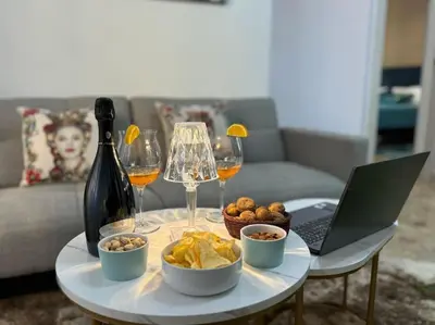 a table with a laptop and glasses of wine and food at La Dimora di Anna e Ciccio in Casteldaccia