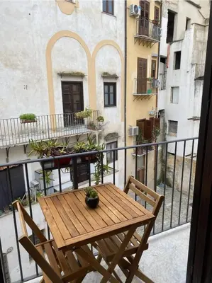 a wooden table and chairs on a balcony at La Barbera's apatments old town PA in Palermo