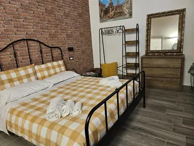 a bedroom with a bed and a brick wall at La Barbera's apatments old town PA in Palermo