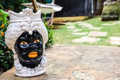 a mask sitting on top of a stone path at Casita Garden&Spa in Carini