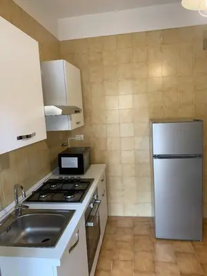 a small kitchen with a stove and a refrigerator at GEORGE PENTHOUSE Attico PALERMO in Palermo