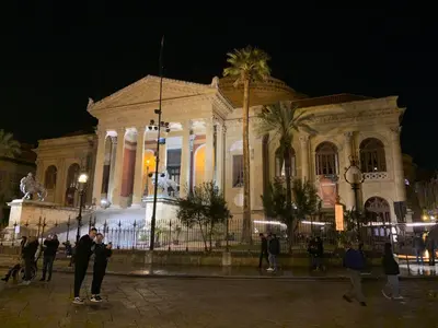 a building with people standing in front of it at night at GEORGE PENTHOUSE Attico PALERMO in Palermo