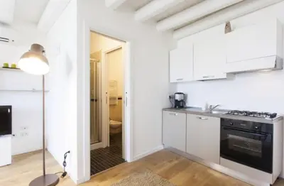 a kitchen with white cabinets and a black stove top oven at Casa Gelsomino POOL&SEAVIEW in Palermo