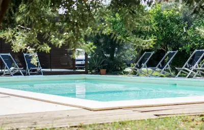 a swimming pool with chairs in a yard at Casa Gelsomino POOL&SEAVIEW in Palermo