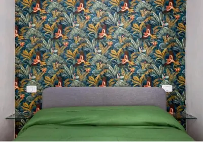 a bedroom with a green bed with a floral wallpaper at Appartamenti Franco il Conte in Bagheria