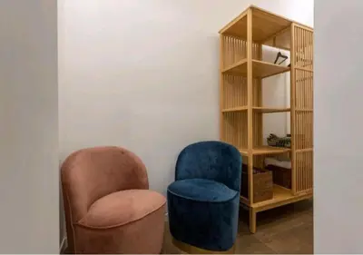two chairs and a book shelf in a room at Appartamenti Franco il Conte in Bagheria