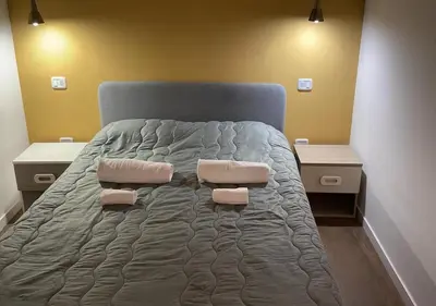a bed in a room with two tables and a bed with two pillows at Appartamenti Franco il Conte in Bagheria