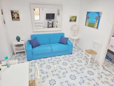 a living room with a blue couch and a mirror at SUITE AND RELAX TINA a 2 passi dal centro e al foro italico in Palermo