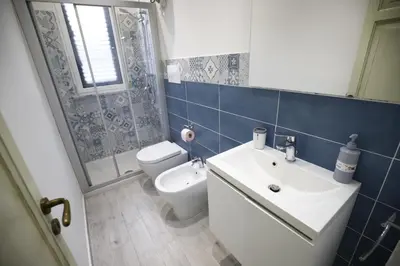 a bathroom with a white sink and a toilet at N'Amùri Casa Vacanze in pieno centro storico in Bagheria