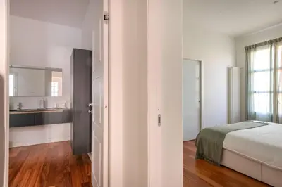 a white bedroom with a bed and a kitchen at Casa Madà vicino al Politeama by Wonderful Italy in Palermo
