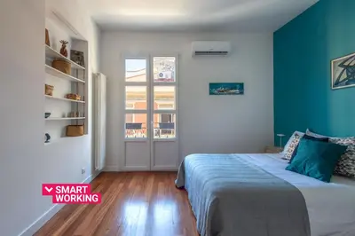 a bedroom with a bed with a blue wall at Casa Madà vicino al Politeama by Wonderful Italy in Palermo