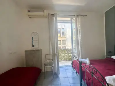 a bedroom with a bed and a sliding glass door at Maqueda Vibes in Palermo