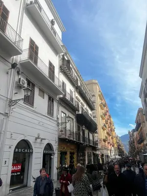 a group of people walking down a street with buildings at Maqueda Vibes in Palermo