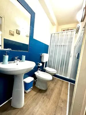 a bathroom with a sink and a toilet and a mirror at Merlino Smarthouse alla Zisa in Palermo