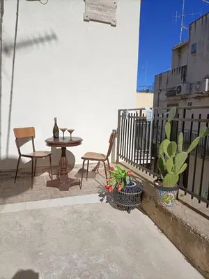 a patio with a table and chairs on a balcony at Casa vacanza la finestra sul porto in Castellammare del Golfo