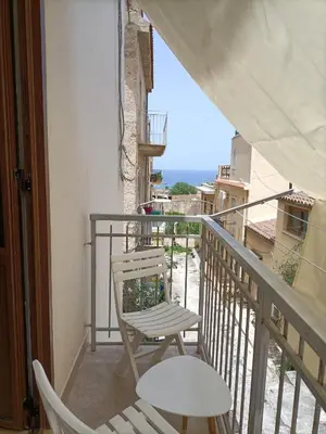 a balcony with a chair and a view of the ocean at Casa vacanza la finestra sul porto in Castellammare del Golfo