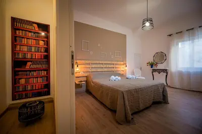 a bedroom with a bed and book shelves with books at Casa vacanza la finestra sul porto in Castellammare del Golfo
