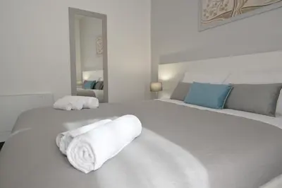 a white bedroom with two white towels on a bed at Da 'Nfacci Affittacamere in Carini