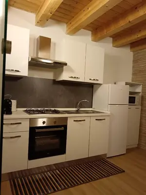 a kitchen with white cabinets and a stove top oven at IGIEA APARTMENT in Palermo