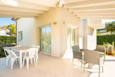 a porch with a table and chairs on a patio at Borgo Aranci - Villa Unifamiliare Ibiscus 08 in Castellammare del Golfo