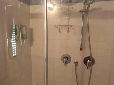 a shower with a glass door with a bench in it at We # Are ai Cassarelli in Palermo