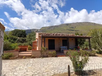 a small house with a mountain in the background at La Terrazza su Pispisa in Castellammare del Golfo