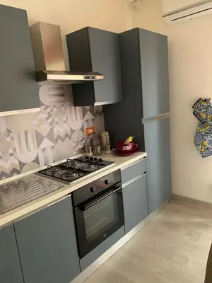 a kitchen with gray cabinets and a stove top oven at Albachiara Termini in Termini Imerese