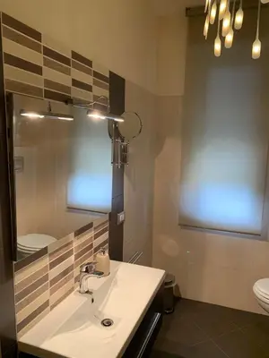 a bathroom with a sink and a mirror and a toilet at Albachiara Termini in Termini Imerese