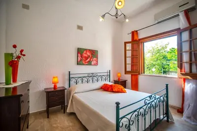 a bedroom with a bed and a window at Villa Reyna in Scopello