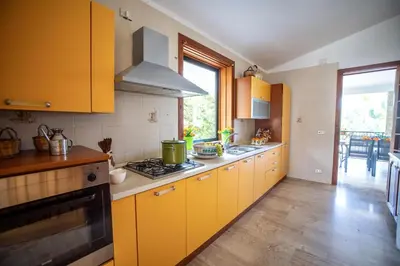 a kitchen with yellow cabinets and a stove at Villa Reyna in Scopello