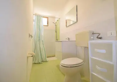 a white bathroom with a toilet and a shower at Villa Reyna in Scopello