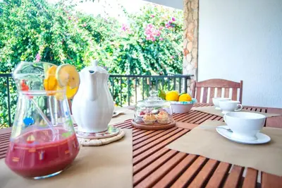 a table with a vase and some fruit on it at Villa Reyna in Scopello