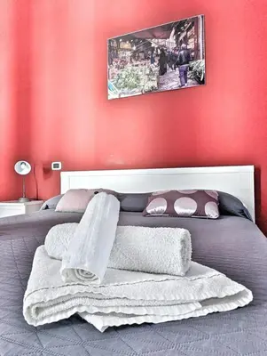 a bedroom with a bed with a red wall at B&B Villareale 35 in Palermo