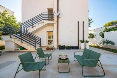 a patio with chairs and a table and stairs at Villa Francesca in Carini