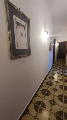 a hallway with a picture on the wall and a tile floor at Casa Di Mitri in Carini