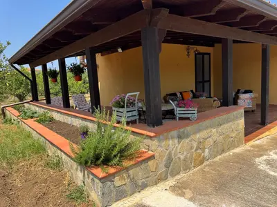 a house with a stone wall and a patio at Le Casette di Campagna in Campofelice di Roccella