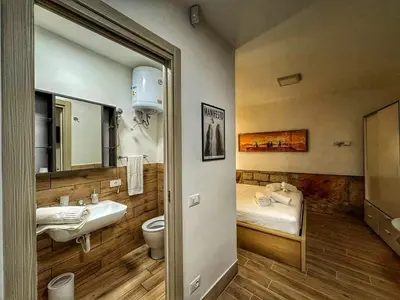 a bathroom with a sink and a toilet and a bed at MaMa5 in Palermo