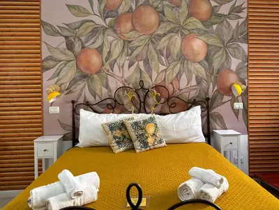 a bedroom with a yellow bed with a floral wall at Orange Lemon Center Palermo in Palermo