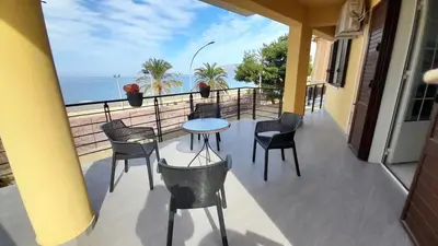 a balcony with a table and chairs and the ocean at Casa L'ORIZZONTE in Balestrate